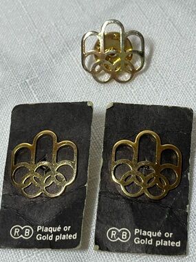 Vintage 1976 Montreal Summer Olympic Games pins featuring a gold-plated design